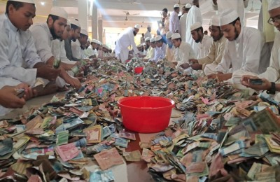 Volunteers working together around a red bowl, tallying and arranging the donations.