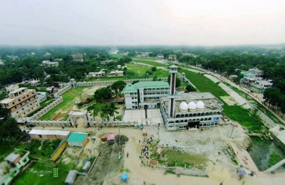 Aerial view of the mosque grounds surrounded by greenery and nearby buildings.